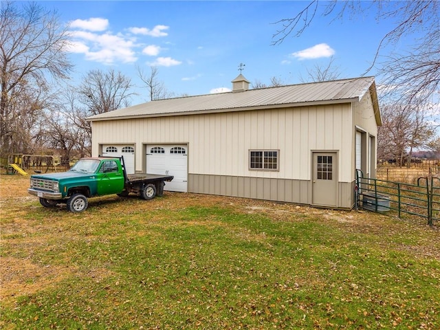 view of property exterior with an outbuilding, a playground, a garage, and a lawn