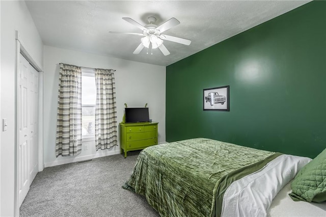 carpeted bedroom featuring a closet and ceiling fan