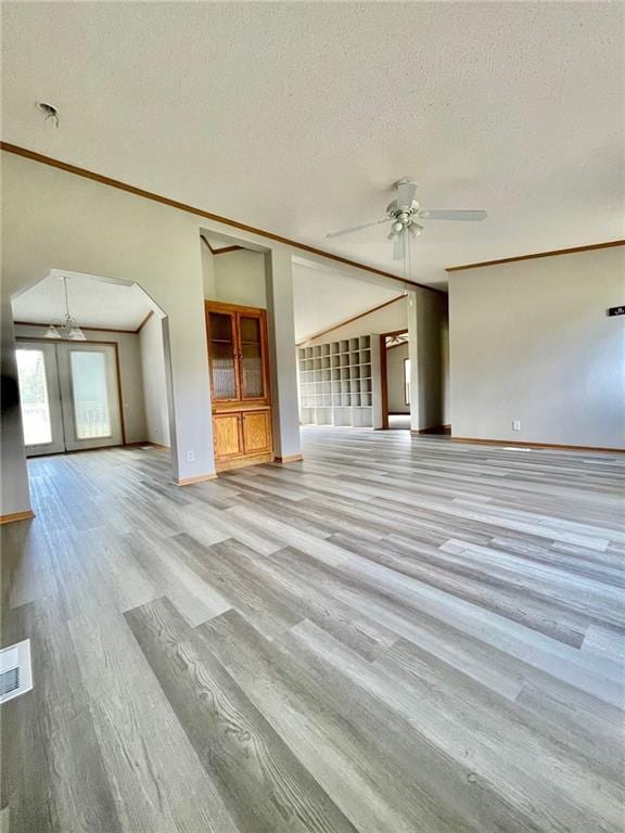 unfurnished living room featuring a textured ceiling, light hardwood / wood-style floors, ceiling fan, and ornamental molding