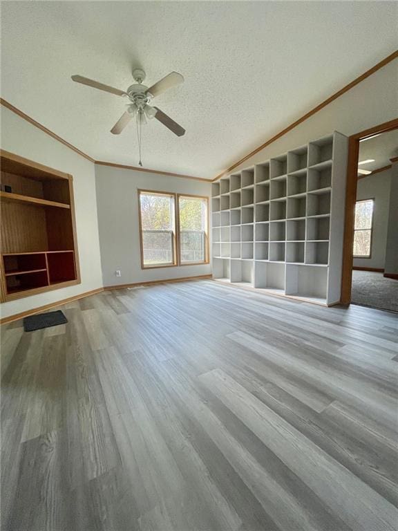 unfurnished living room with a textured ceiling, light hardwood / wood-style floors, ceiling fan, and crown molding