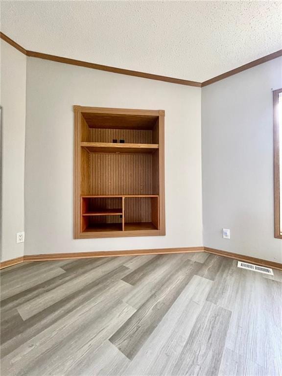 spare room featuring wood-type flooring and a textured ceiling