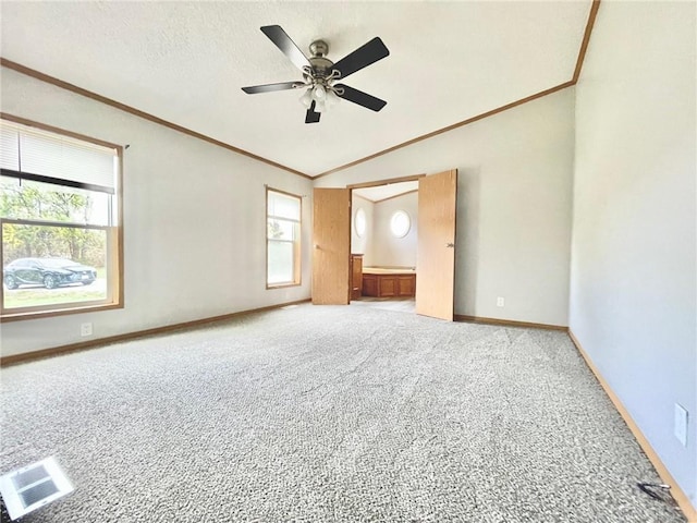 carpeted spare room with crown molding, ceiling fan, and lofted ceiling