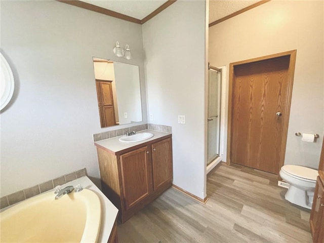 full bathroom featuring crown molding, vanity, hardwood / wood-style flooring, and shower with separate bathtub