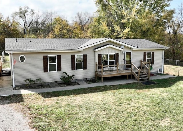 back of house featuring a lawn and a wooden deck