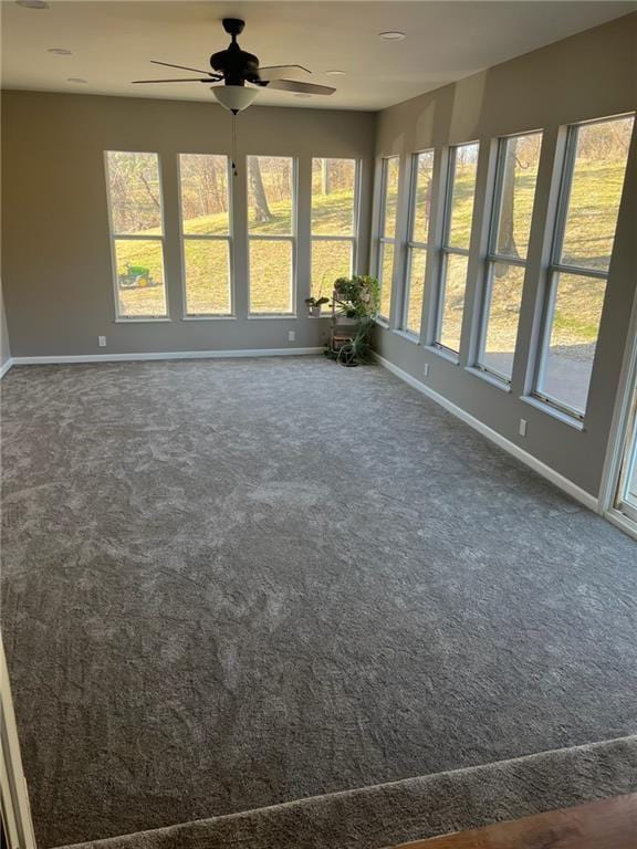 unfurnished sunroom featuring ceiling fan