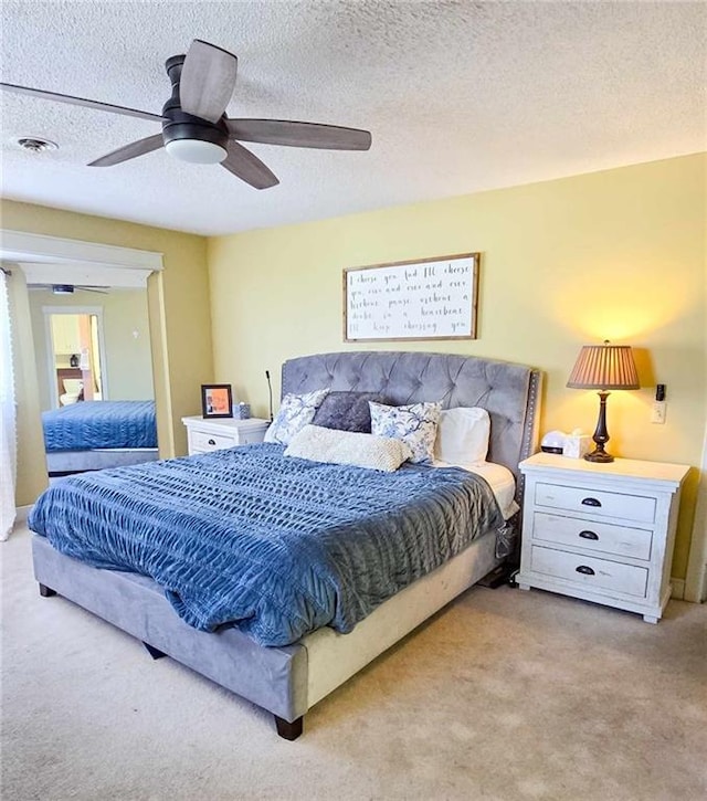 bedroom with carpet, ceiling fan, and a textured ceiling