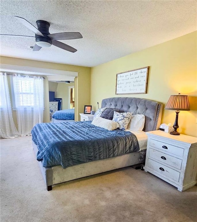 bedroom featuring ceiling fan, a textured ceiling, and carpet