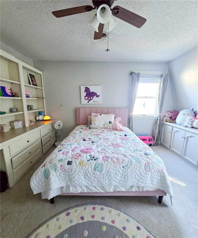 bedroom featuring ceiling fan, a textured ceiling, and light carpet