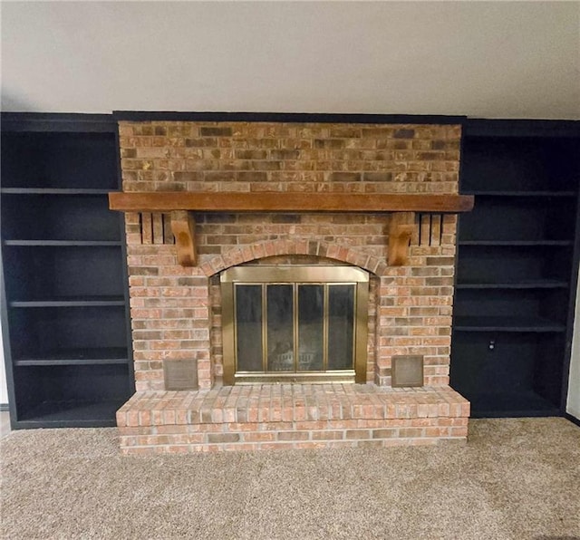 room details featuring carpet floors, built in shelves, and a fireplace