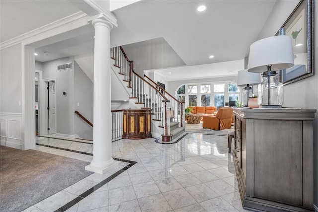 foyer entrance with ornate columns, visible vents, crown molding, and recessed lighting