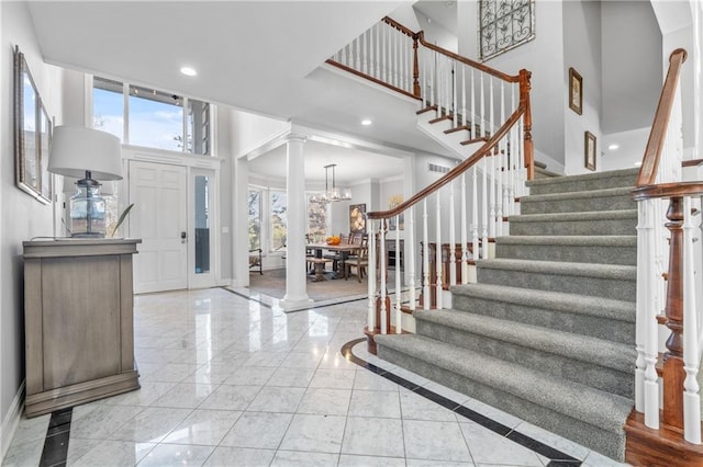 entrance foyer with stairs, a high ceiling, decorative columns, and recessed lighting