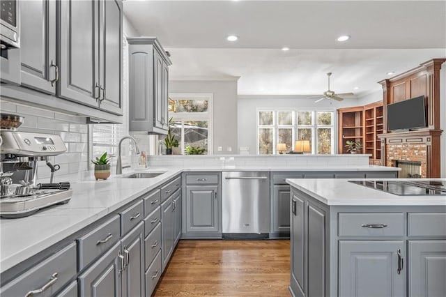 kitchen with dark wood finished floors, black electric stovetop, gray cabinets, backsplash, and a sink