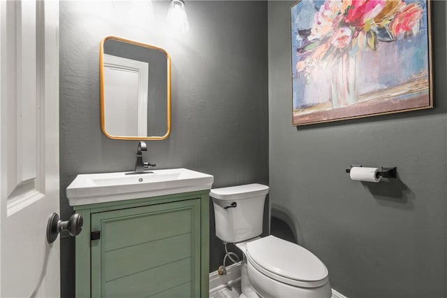 bathroom featuring vanity, toilet, and baseboards