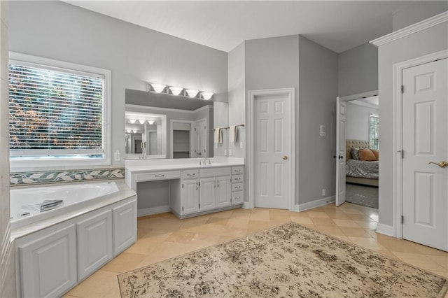 ensuite bathroom with a healthy amount of sunlight, a garden tub, ensuite bath, and tile patterned floors