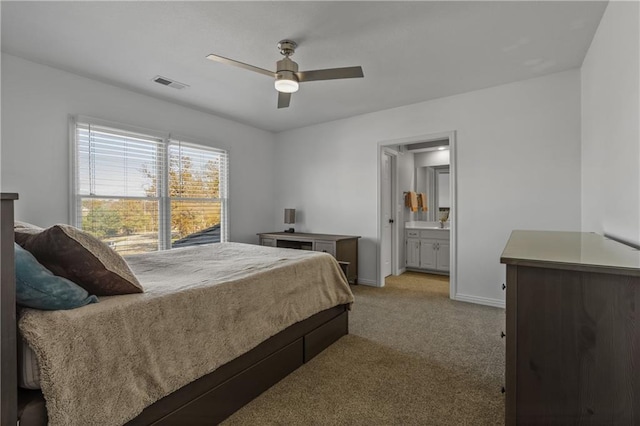 bedroom featuring baseboards, visible vents, connected bathroom, a ceiling fan, and light colored carpet