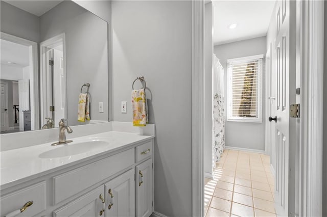 full bath with tile patterned flooring, baseboards, and vanity