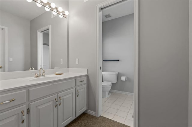 bathroom featuring toilet, visible vents, vanity, baseboards, and tile patterned floors