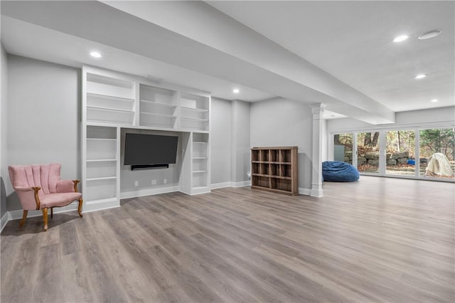 interior space featuring recessed lighting, ornate columns, baseboards, and wood finished floors