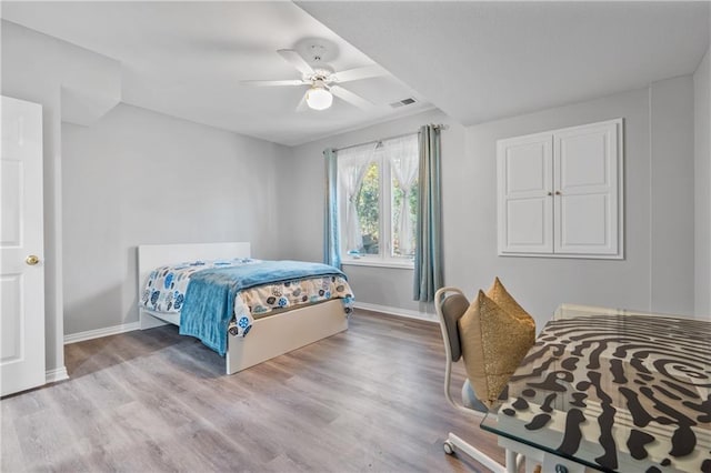 bedroom with light wood-style flooring, visible vents, ceiling fan, and baseboards