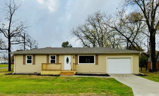 ranch-style home featuring a front lawn and a garage