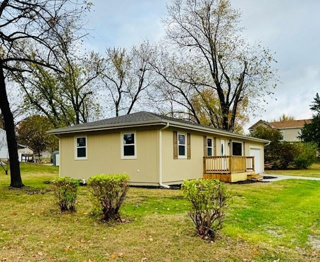 rear view of house with a deck and a yard