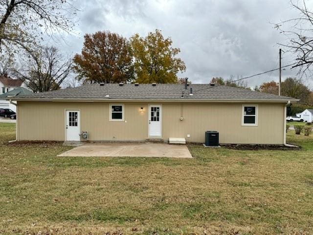 back of house featuring cooling unit, a patio area, and a lawn