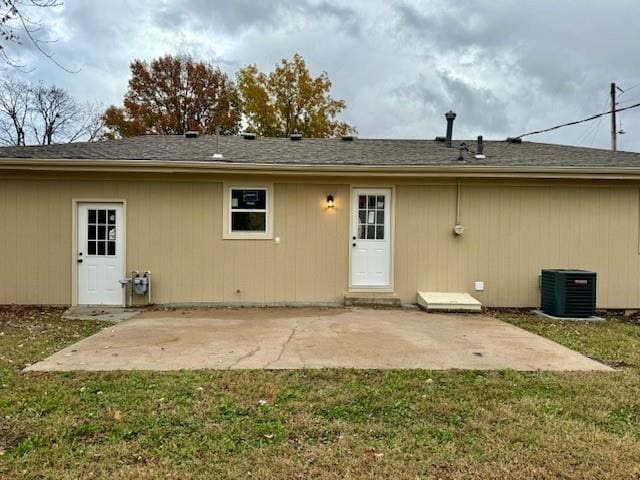 rear view of property with a patio, central AC, and a lawn