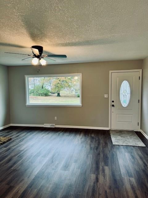 foyer featuring dark wood-type flooring, ceiling fan, and a textured ceiling