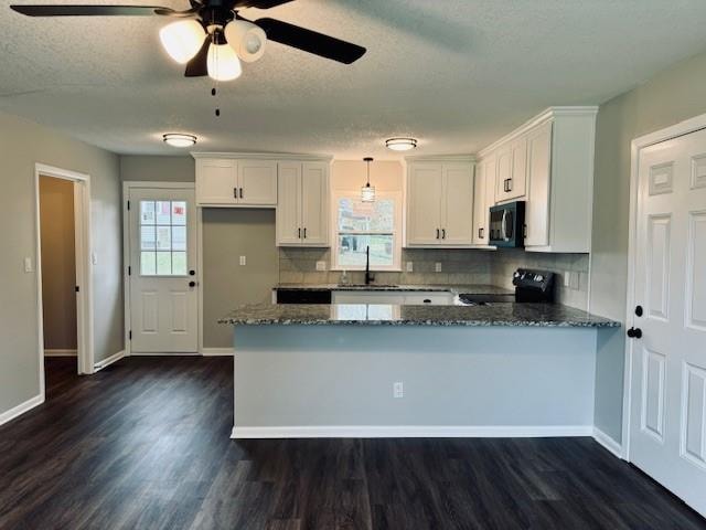 kitchen with black appliances, backsplash, white cabinets, dark stone countertops, and dark hardwood / wood-style floors