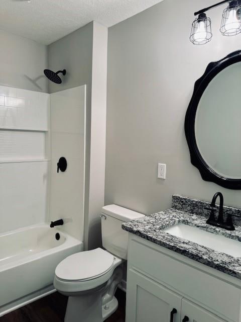 full bathroom with bathing tub / shower combination, a textured ceiling, hardwood / wood-style floors, toilet, and vanity