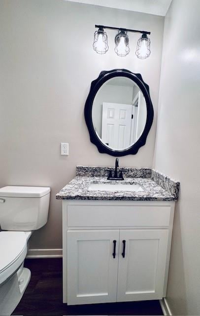 bathroom with vanity, hardwood / wood-style flooring, and toilet