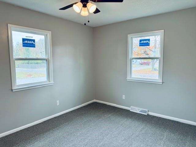 unfurnished room with ceiling fan and carpet