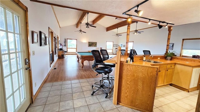 home office with lofted ceiling with beams, billiards, light wood-type flooring, and a wealth of natural light