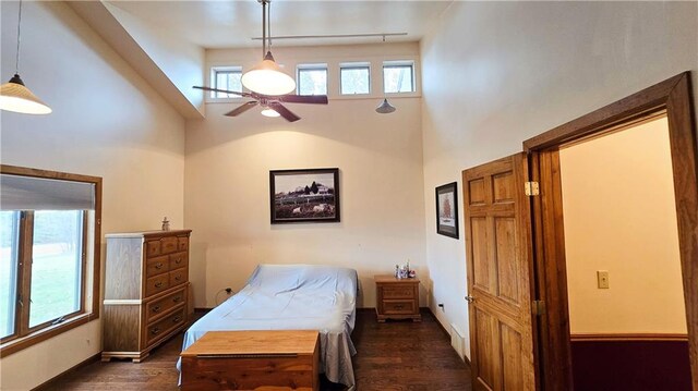 bedroom featuring dark hardwood / wood-style floors, high vaulted ceiling, and ceiling fan