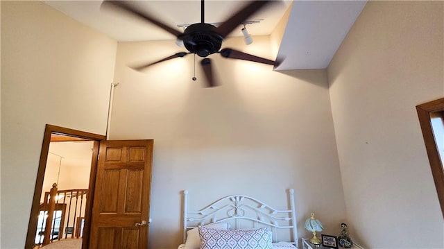 bedroom featuring ceiling fan and a towering ceiling