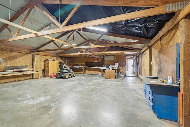 misc room featuring vaulted ceiling and concrete flooring