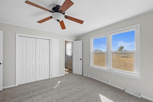 unfurnished bedroom featuring a closet, ceiling fan, and carpet flooring