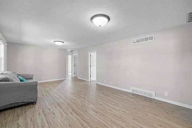 living room with a textured ceiling and light hardwood / wood-style flooring