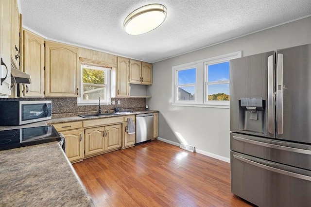 kitchen featuring dark hardwood / wood-style floors, sink, appliances with stainless steel finishes, a textured ceiling, and tasteful backsplash