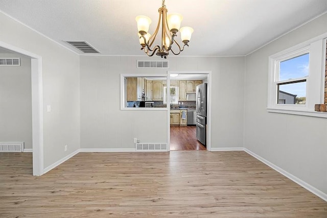 unfurnished dining area with hardwood / wood-style flooring and a chandelier