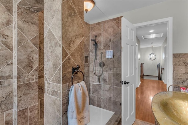 bathroom featuring vanity, wood-type flooring, and tiled shower