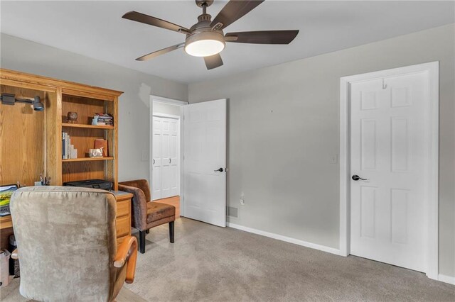 living area featuring ceiling fan and carpet