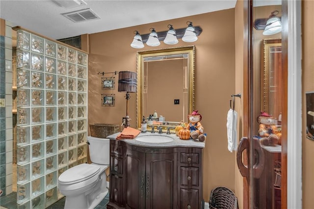 bathroom featuring vanity, toilet, and walk in shower