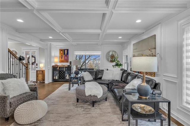 living room featuring beamed ceiling, wood-type flooring, ornamental molding, and coffered ceiling