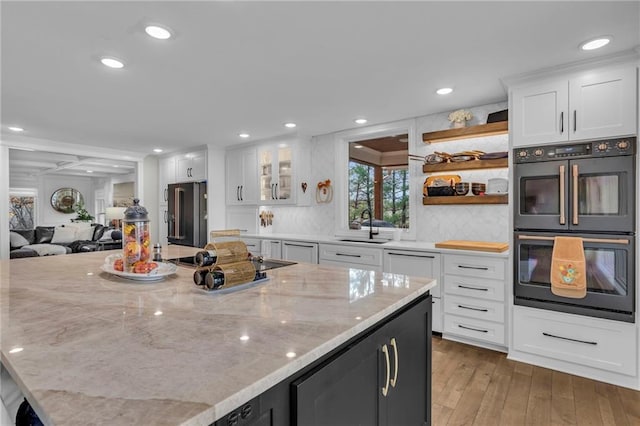 kitchen with white cabinetry, hardwood / wood-style floors, and light stone counters