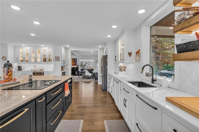 kitchen featuring backsplash, white cabinets, sink, black electric cooktop, and dark hardwood / wood-style flooring