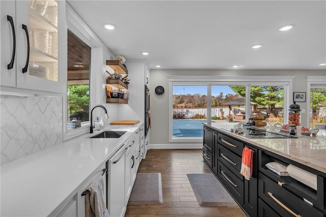 kitchen featuring tasteful backsplash, black electric cooktop, sink, white cabinets, and dark hardwood / wood-style floors