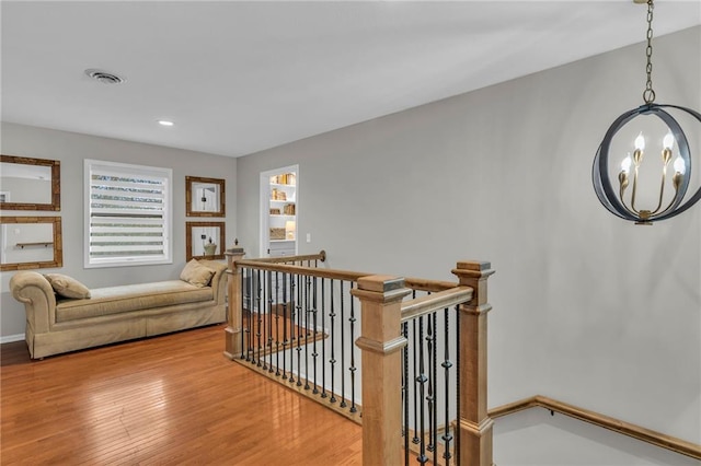 corridor featuring a notable chandelier and hardwood / wood-style flooring