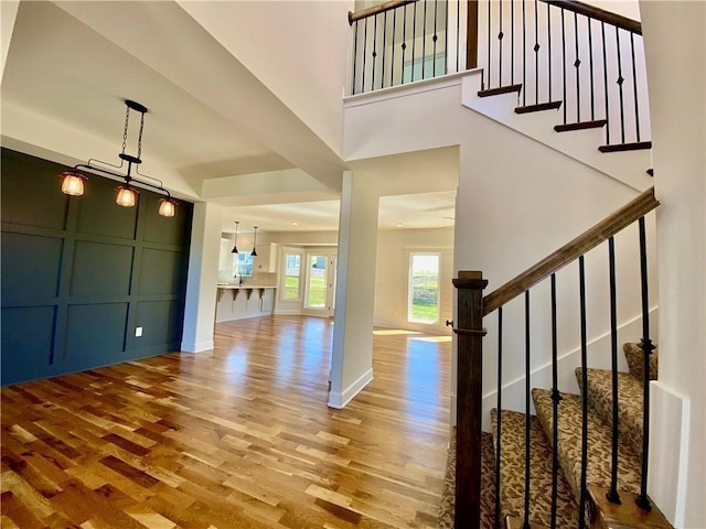 entryway featuring hardwood / wood-style flooring and a towering ceiling