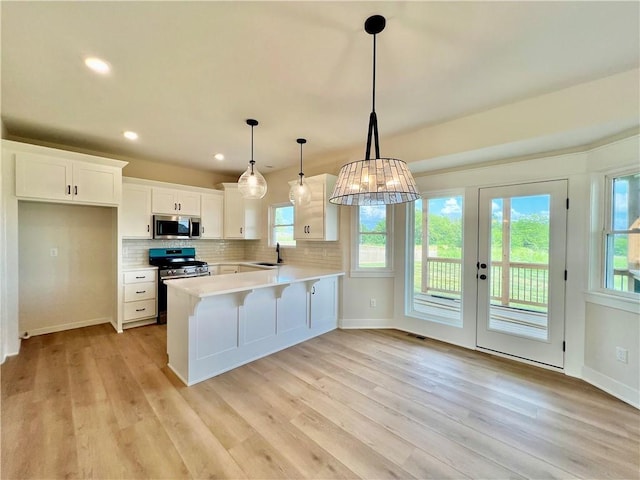 7709 NE 106th Pl, Kansas City, MO 64157 - kitchen with appliances with stainless steel finishes, light countertops, healthy amount of natural light, light wood-style floors, and recessed lighting